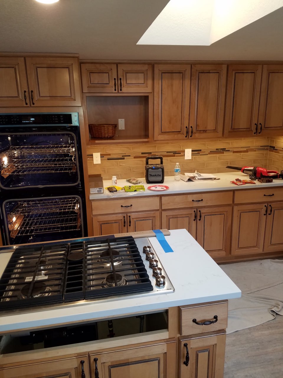 Wood-cabinet kitchen with double ovens and cooktop